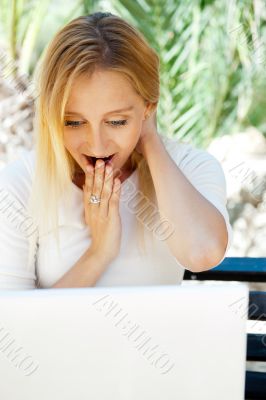 Beautiful woman using laptop while sitting relaxed on bench at s