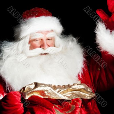 Santa sitting at the Christmas room and looking into the sack