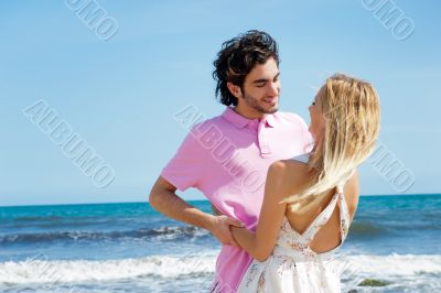 Young couple at beach, embracing, side view. Natural emotions. H