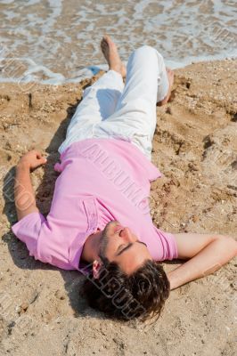 Portrait of attractive and happy man on the beach relaxing and d