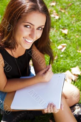 A shot of an caucasian student studying on campus lawn