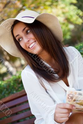 Portrait of young pretty woman sitting on bench at summer or aut