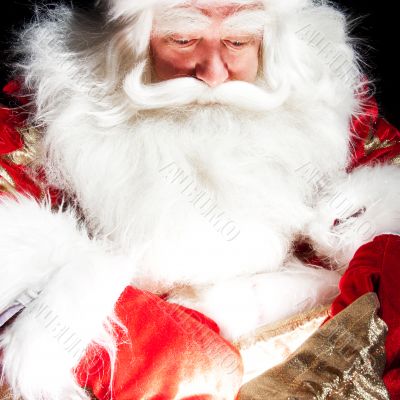 Santa sitting at the Christmas room and looking into the sack