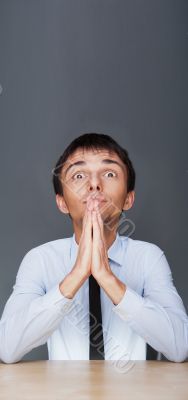 Profile shot of professional man holding hands up to face agains