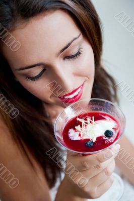 Portrait of an young beautiful woman eating an ice cream in cafe
