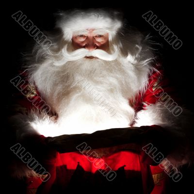 Santa sitting at the Christmas room and looking into the sack