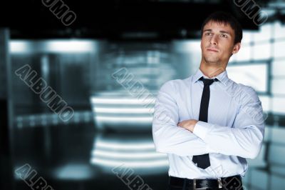 Closeup of a young smiling business man standing in a light and 