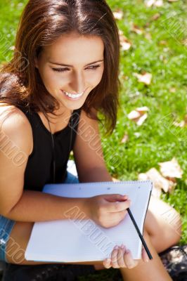 A shot of an caucasian student studying on campus lawn