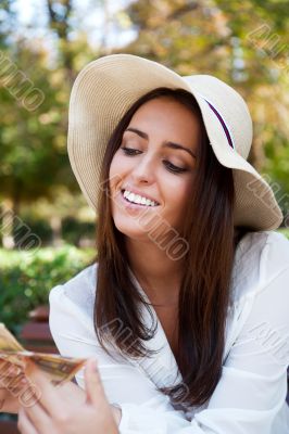 Portrait of young pretty woman sitting on bench at summer or aut