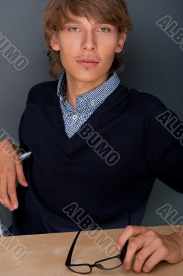 Portrait of young, handsome man thinking while sitting relaxed a