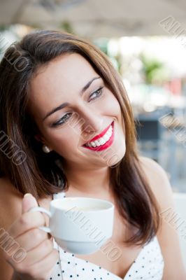 Closeup portrait of a pretty young female having a cup of coffee