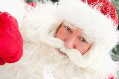 Portrait of Santa Claus standing with hand on chin outdoors at c