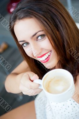 Closeup portrait of a pretty young female having a cup of coffee