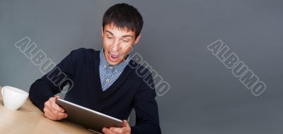 Closeup of a young smiling business man sitting at his office ag