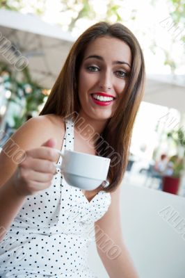 Closeup portrait of a pretty young female having a cup of coffee
