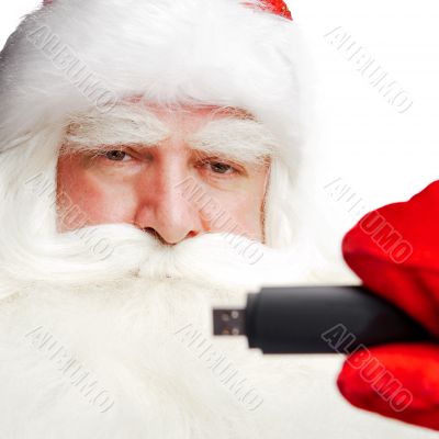 Traditional Santa Claus holding 3g usb modem in his arm on foreg