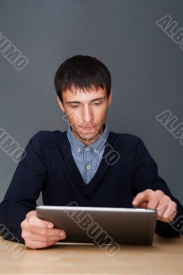 Closeup of a young smiling business man sitting at his office ag