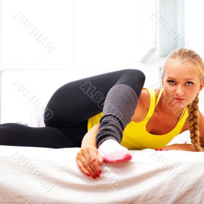 Portrait of beautiful young woman doing exercise at her home
