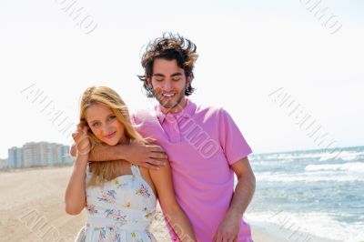 Couple at the beach holding hands and walking. Sunny day, bright