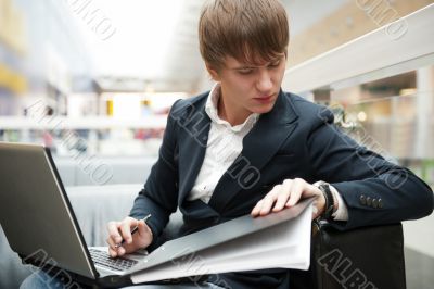 Portrait of handsome young man working with laptop at cafe at bu