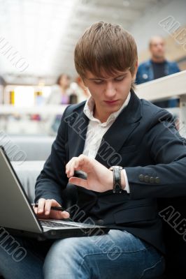 Portrait of handsome young man working with laptop at cafe at bu