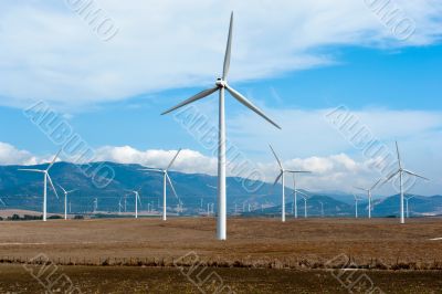 Wind power station - wind turbine against the blue sky