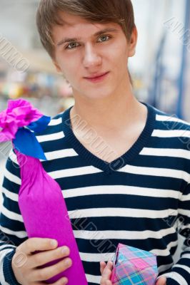 Portrait of young man inside shopping mall standing relaxed and 