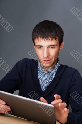 Closeup of a young smiling business man sitting at his office ag