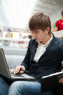Portrait of handsome young man working with laptop at cafe at bu