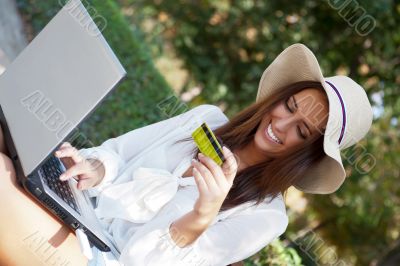 Young elegant woman wearing straw hat and white dress holding cr