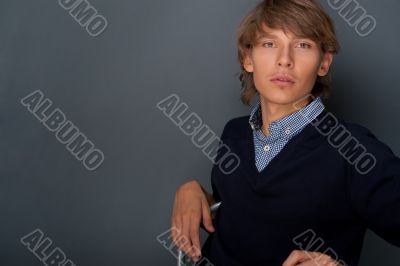 Portrait of young, handsome man thinking while sitting relaxed a