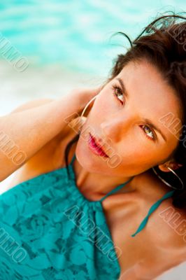 Pretty young woman with hot look and sexy smile sitting on beach