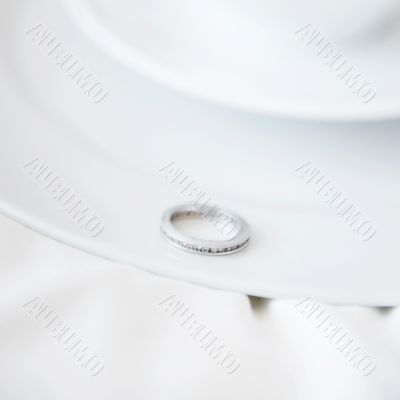 Closeup photo of proposal ring on white plate of coffee cup and 