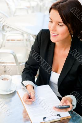 Business woman working with documents while having lunch or brea