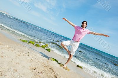 Portrait of young man standing carefree with outstretched arms o