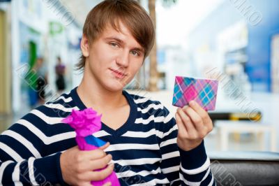 Portrait of young man inside shopping mall standing relaxed and 