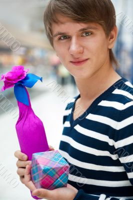 Portrait of young man inside shopping mall standing relaxed and 