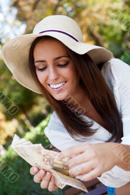 Portrait of young pretty woman sitting on bench at summer or aut