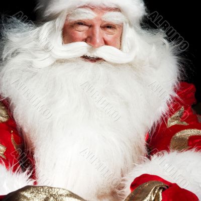 Santa sitting at the Christmas room and looking into the sack