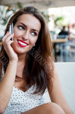 Closeup portrait of a pretty young female sitting at cafe in mor