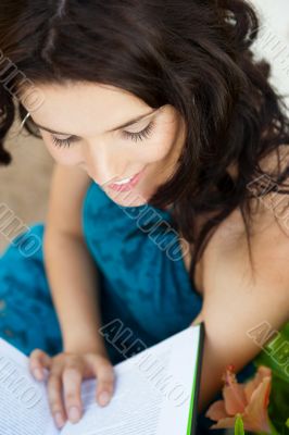 Pretty relaxed adult woman reading a book at the park