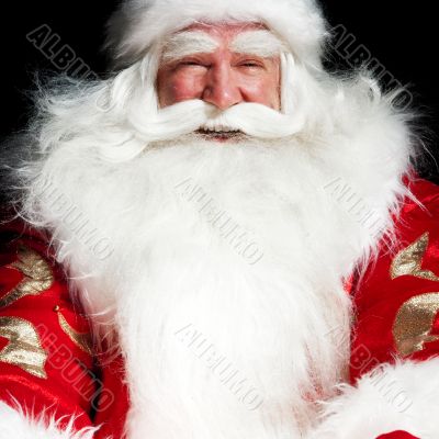 Santa sitting at the Christmas room and looking into the sack