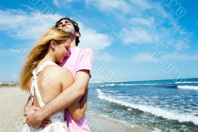 Young couple at beach, embracing, side view. Natural emotions. H