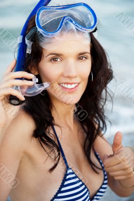 Young hispanic woman with wet skin and with a snorkel standing o