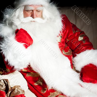 Santa sitting with a sack indoor at dark night room