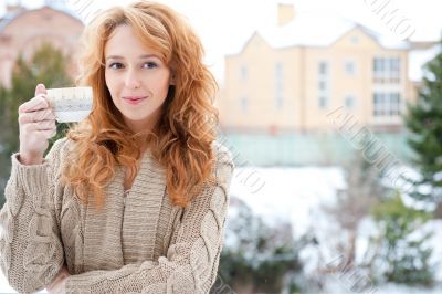 Portrait of young pretty red hair woman with cup of hot coffee o