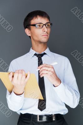 Closeup of a young smiling business man standing confidently aga