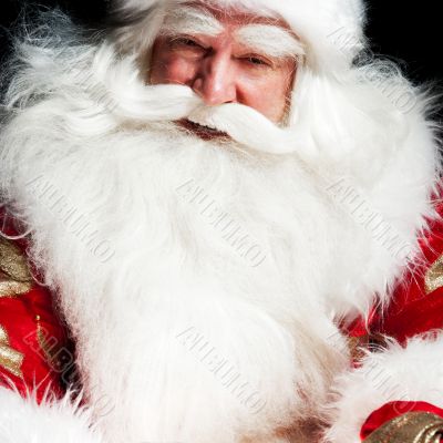 Santa sitting at the Christmas room and looking into the sack