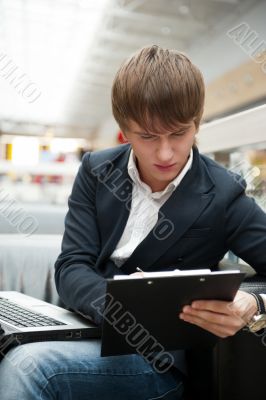 Portrait of handsome young man working with laptop at cafe at bu