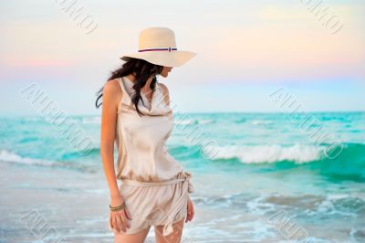 Young beautiful sexy tanned brunette woman wearing straw hat and